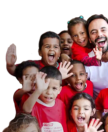 Un grupo de niños sonrientes saludando, vistiendo camisetas rojas de Colgate, junto a un hombre sonriente con camisa blanca.